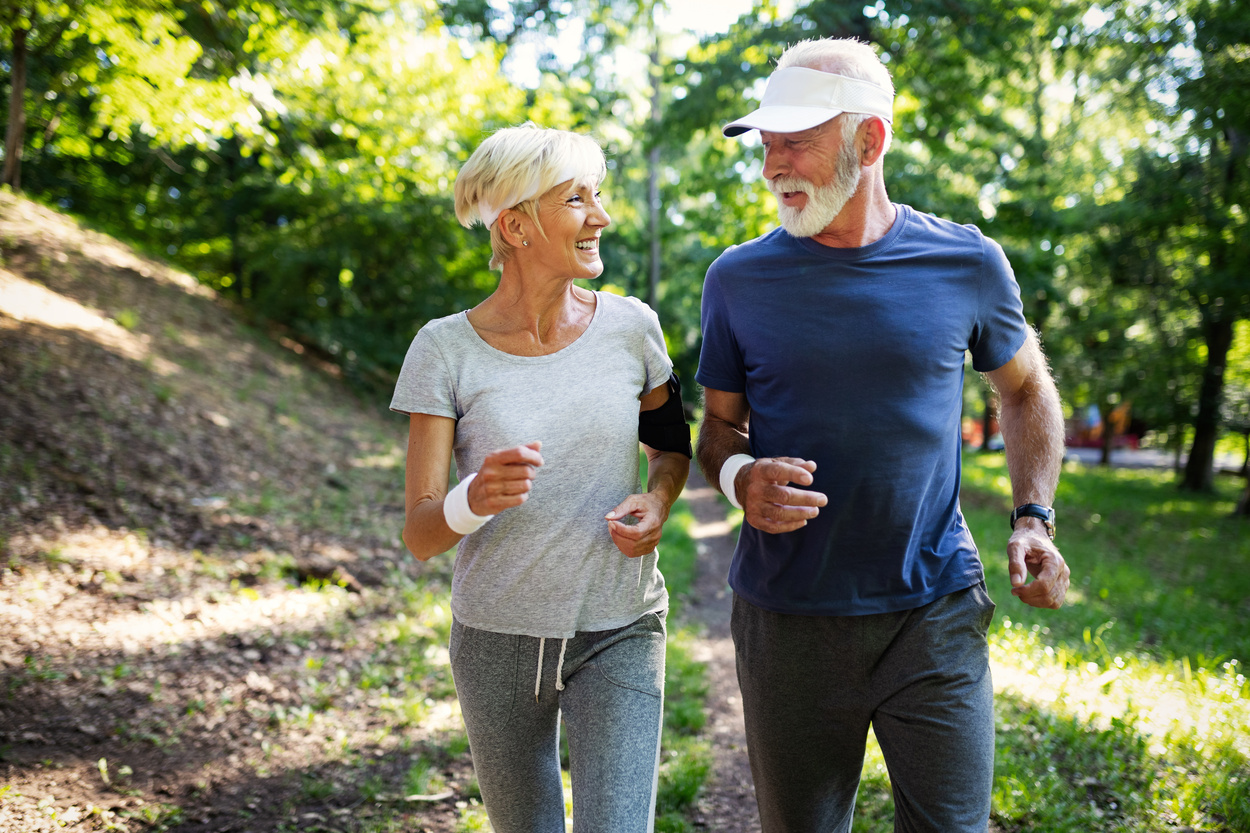 Senior couple jogging and running outdoors in nature