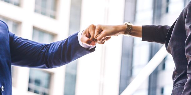 Businessman and partner giving fist bump hand