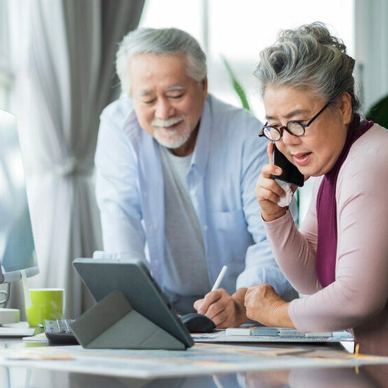 old senior asian retired people entrepreneur working together at homehome isolation remote jobs work with desktop and smartphone technology device work from home